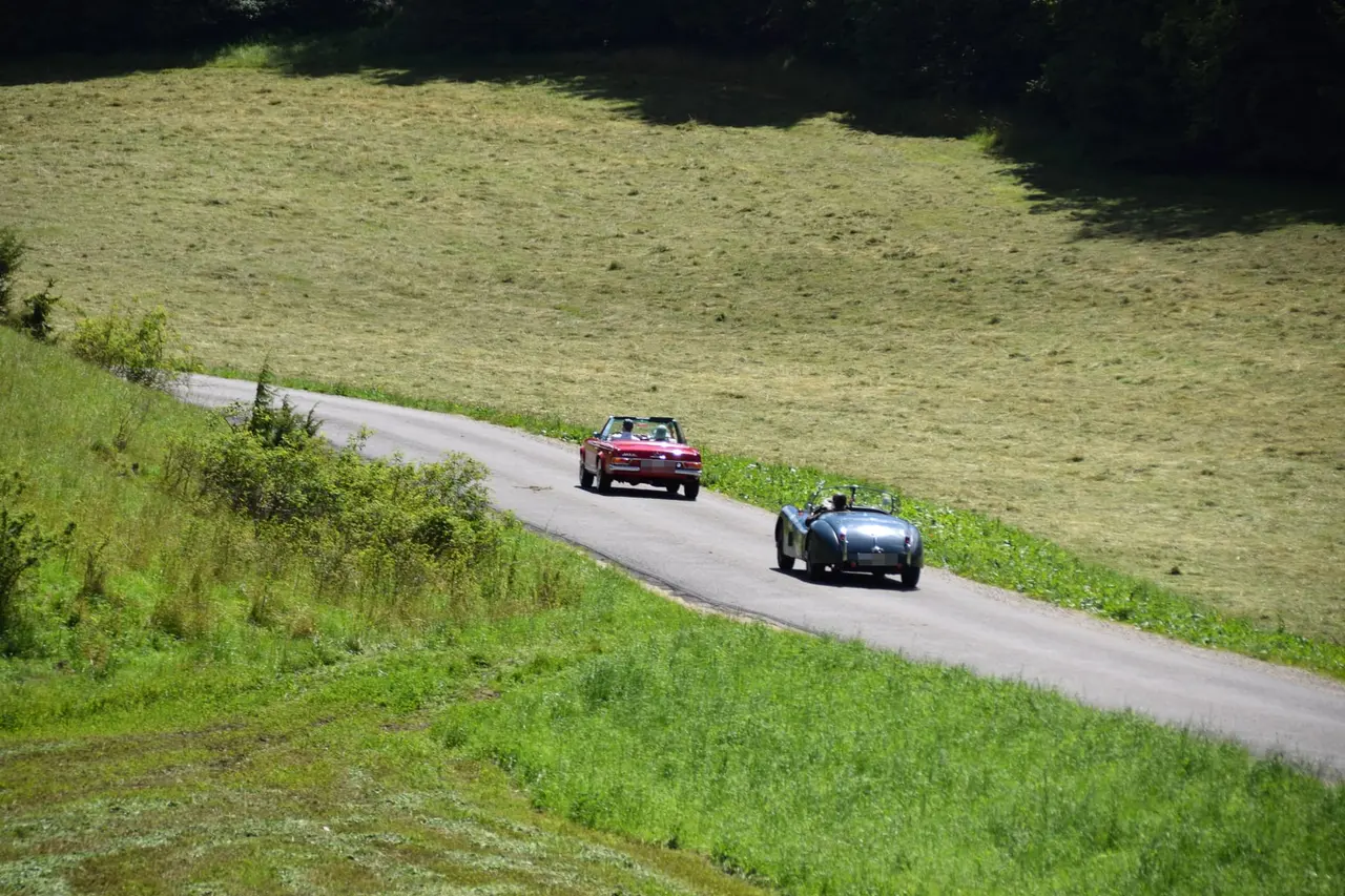 Mercedes SL Pagode und Jaguar XK in einer Kurve der Schwäbischen Alb, von oben gesehen