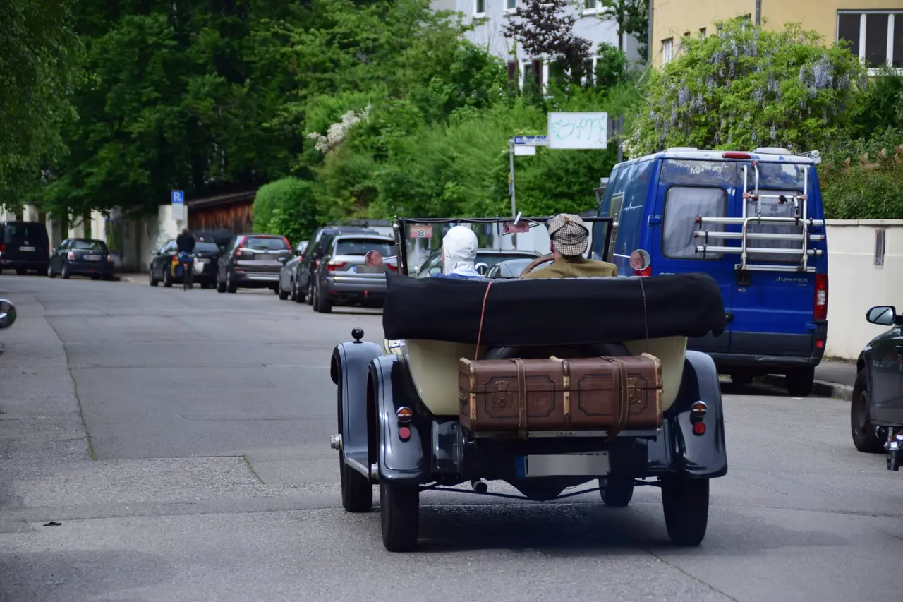 Vorkriegs-Tourenwagen mit Reisekoffer auf der Straße