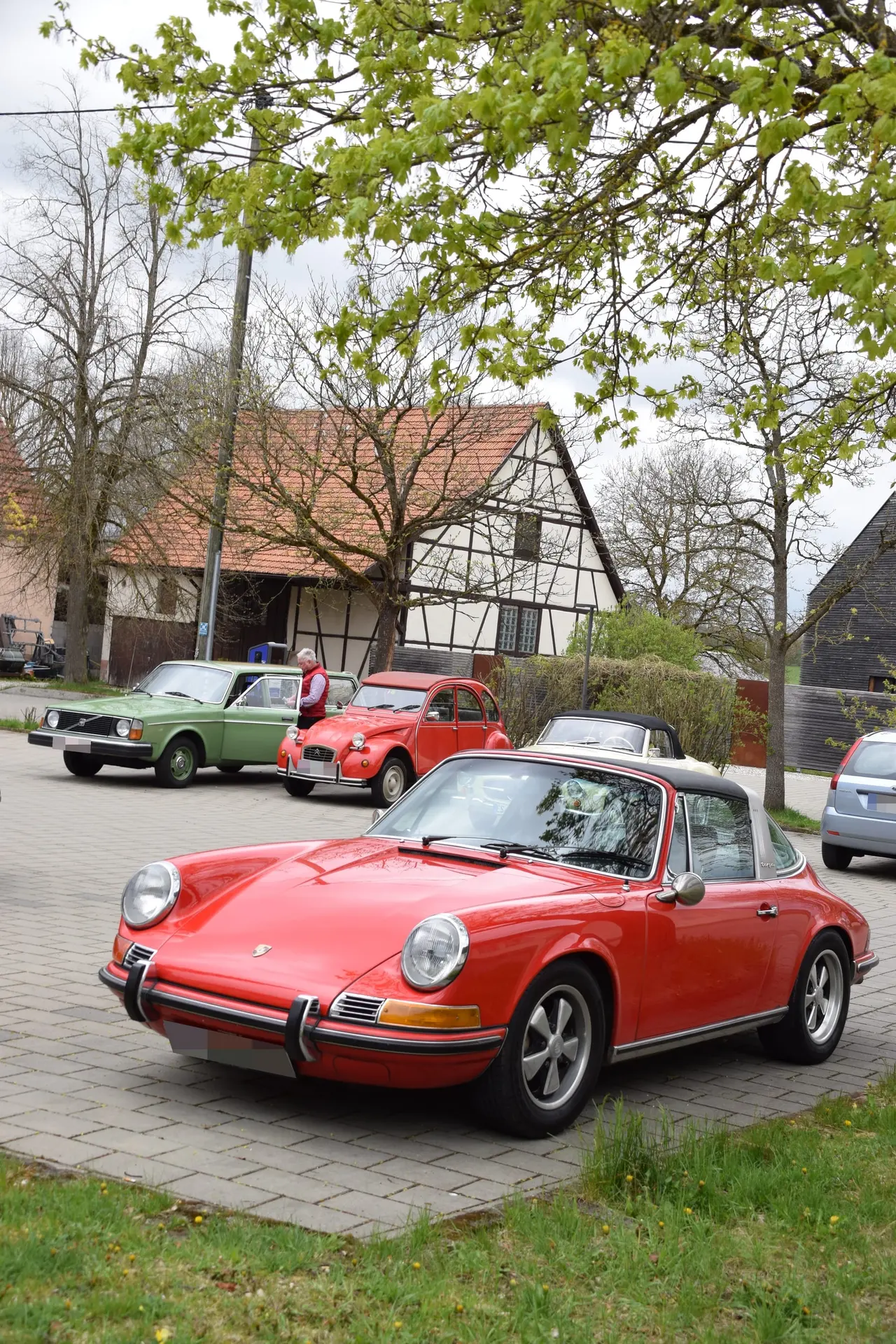 Roter Oldtimer unter blühenden Bäumen