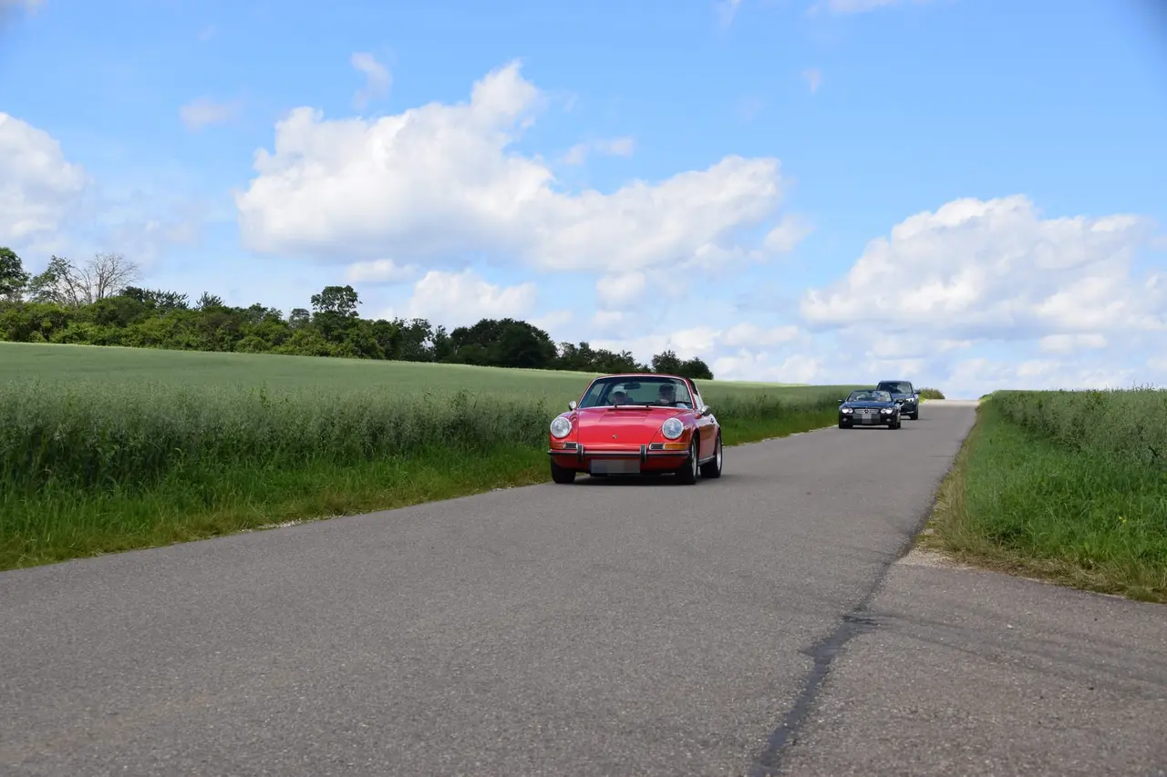 Oldtimer auf der Landstraße unter Sommerwolken